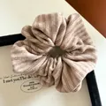 Detail of a beige striped knit scrunchie inside a minimalist wooden jewelry box display - Khaki Striped