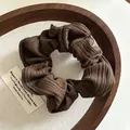 Detailed view of dark brown ribbed knit hair scrunchie on a decorative wooden tray - Dark Coffee