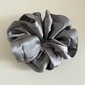 Macro view of silver grey satin scrunchie showing detailed silk texture and edges - Blue Gray