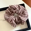 Detailed view of a brown and white striped fabric scrunchie with soft pleated texture - Brown Stripes