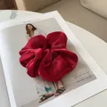 Gros plan d'un grand chouchou en satin rouge plissé sur un magazine de mode chic - Bordeaux