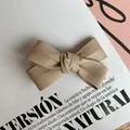 Primer plano de pasador de lazo en cuero PU beige sobre una página de revista - Albaricoque