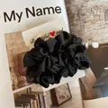 Macro d'un chouchou en soie noire au lustre satiné sur une carte de présentation - Noir