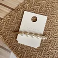 Detail of elegant handmade pearl hair clip with gold metal base on branding card - Alternating Size Long Pearl Style (Style B) / Style B