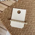 Detailed view of handmade pearl hair clip with gold metal base on a jewelry card - Uniform Size Row Pearl Style (Style D) / Style D