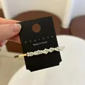 Detailed macro view of French style golden barrette with woven white pearls on card - Densely Packed Wave Double Row Pearl Style (Style C) / Style C