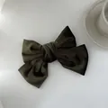 Detailopname van fluwelen strik haarclip met zachte stoftextuur en elegante donkergroen - Legergroen