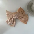 Detail van een grote fluwelen haarstrik in beige met meerlagig geplooid ontwerp - Off-wit
