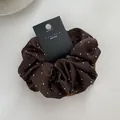 Macro detail of dark brown satin scrunchie with rhinestones and brand packaging card - Dark Coffee