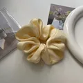 Premium cream satin scrunchie with soft silk texture for elegant hair styling - Yellow