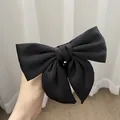 Close-up of a large black satin bow hair tie with elegant layered fabric texture - Black