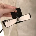 Dettaglio del fiocco per capelli coreano con strass centrali e nastro bianco e nero - Fermaglio Becco d'Anatra Bianco Crema