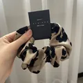 Detail of cow and leopard print hair scrunchies with soft texture on a display card - Khaki Base Spotted Print / Khaki