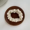 Silky cream white satin scrunchie hair tie displayed on a premium dark wood tray - S / Off-white
