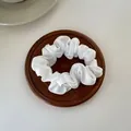 Elegant white satin scrunchie with silky texture and natural folds on a wooden coaster - S / White
