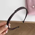 Nahaufnahme des tiefbraunen dreisträngigen Haarreifs aus Kunstleder mit geknotetem Detail - Dünner Knoten Haarreif / Dunkelbraun