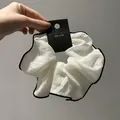 Λεπτομέρεια από λευκό scrunchie με μαύρη άκρη πάνω σε κάρτα προϊόντος από την Κορέα - Λευκό