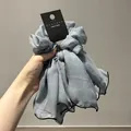 Dettaglio dell'elastico per capelli in organza blu con nastri e cuciture nere - Blu