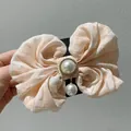 Detail of checkered fabric bow hair clip with central pearl and rhinestone pendant - Elegant Pink