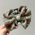 Nahaufnahme einer karierten Stoff-Haarspange mit großer Perle und Strass-Verzierung - Matcha-Grün