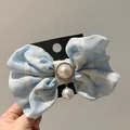 Details einer hellblauen karierten Stoffschleife mit Perlenanhänger und Kristall - Hellblau