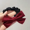 Close-up of a vintage velvet bow hair scrunchie with red suede fabric detail - Burgundy