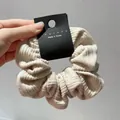 Detail of beige striped fabric scrunchie with pleated texture and Korea brand tag - Beige Large