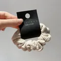Detail of cream striped fabric scrunchie with knit texture on a branded card - Beige Small