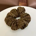 Detailopname van een diepbruine scrunchie met wafelstructuur op witte tafel - Haarelastiek C