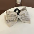 Detail einer übergroßen beige-karierten Haarklammer mit dreireihigem Kunstperlenbesatz - Beige Perle Schleife Haarkralle