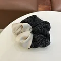 Detail of tweed and champagne satin patchwork scrunchie with elegant fabric texture - Black White Splicing Hair Ring