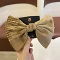 Detail van een grote kaki fluwelen en satijnen patchwork haarclip op een kaart - Strik Haarspeld - Koffie