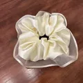Elegant cream satin scrunchie with layered organza trim on a rustic wood background - Off White
