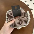 Haargummi aus braunem Samt mit schwarz-weiß gewebter Kante und eleganten Fransen - Kaffeebraun
