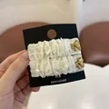Λεπτομέρεια από κλιπ μαλλιών σε κρεμ λινό με φθαρμένες άκρες και χρυσούς φιόγκους - Κλιπ BB - Κρέμα Ζεύγος