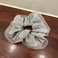 Detalle de coletero de tela a rayas azules con borde de tul marrón sobre madera - Gris Azulado