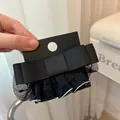 Detailansicht der strukturierten schwarzen Ripsbandschleife mit weißem Mesh-Spitzenrand - Netzschleifen-Stil / Schwarz