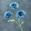 Three-headed artificial blue hibiscus flower with green leaves on grey fabric background - Deep Blue