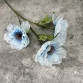 Drei Köpfe künstliche lichtblaue Pfingstrose Seidenblume mit grünen Blättern auf grauem Grund - Blau