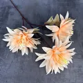 Bouquet de trois têtes de chrysanthèmes artificiels orange abricot sur fond de pierre grise - Chair