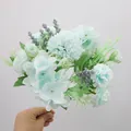 Artificial bouquet with light blue peonies and hydrangeas held against gray backdrop - Blue Rose Hydrangea