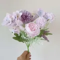 Pink peony and purple hydrangea bouquet with green leaves held by hand for decor - Purple Peony Hydrangea