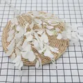 Artificial white peanut leaf branch with berries on a rustic woven table mat - White