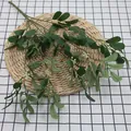 Artificial peanut leaf bundle with green foliage and small white berries on straw mat - Green