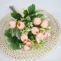 Faux peach rose bud bouquet with green leaves on a woven mat for home decoration - Champagne Pink