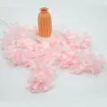 Rama de cerezo artificial de seda rosa suave con tallos finos en un jarrón color naranja - Rosa