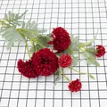 Artificial red dandelion flower bouquet with lush petals on a checkered background - Red