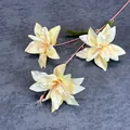 Three artificial lilies with creamy yellow silk petals and pink stems on gray background - Champagne