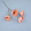 Pink orange artificial magnolia branch with four flower heads on light blue surface - Dusty Rose