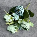 Ramo de flores de seda de ranúnculo cian vintage con hojas verdes sobre fondo gris - Azul